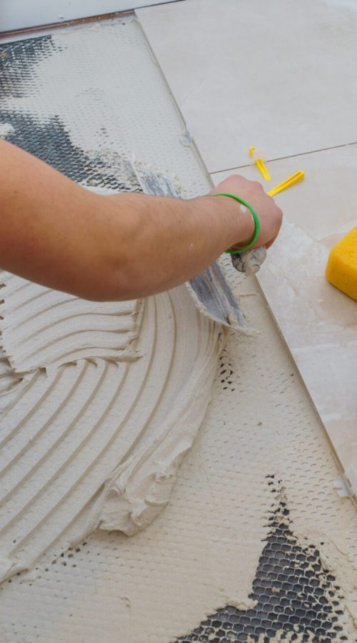Applying new tiles on bathroom floor tile installation for house building