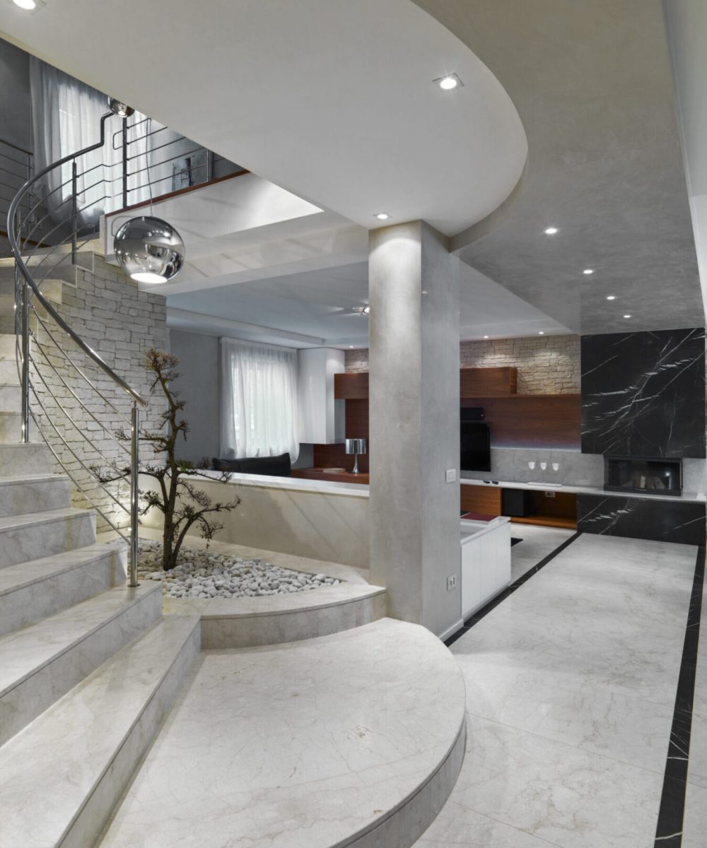 modern living room interior in the foreground the masonry staircase with steel railing on the background the fireplace