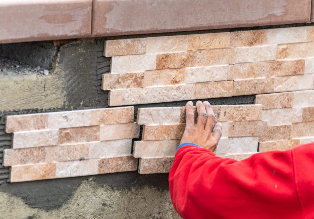 Worker Installing Wall Tile at Construction Site.